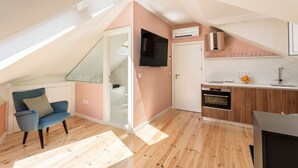 Een modern appartement met een keuken, een eethoek en een woonkamer met een blauwe stoel.