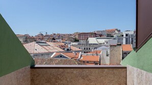 Uitzicht op een stadsbeeld vanaf een balkon, met gebouwen op de achtergrond.