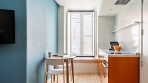 Eine kompakte Küche mit Essbereich, einem großen Fenster und Blick auf die Straße.