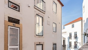 A narrow street with buildings featuring balconies and windows. - JOIVY  Homey Suite near Rossio Square (Lisboa)
