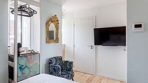 A bedroom with a bed, a chair, a TV, a wardrobe, and a mirror. - JOIVY  Homey Suite near Rossio Square (Lisboa)