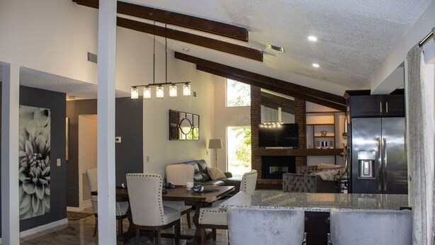 A modern kitchen with a large island, built-in appliances, and a dining area with a fireplace. -  Private  Pool Home 
Nestled on the Golf Course (North Fort Myers)