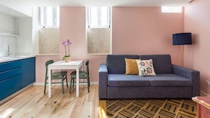 A modern living space with a dining area, a sofa, and a lamp.