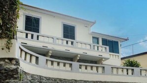 Un bâtiment moderne doté d’une façade en pierre et d’une entrée sécurisée par un portail.
