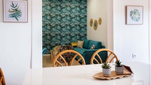 Un coin repas avec une table blanche, des chaises et des plantes en pot.