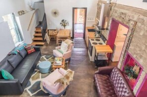 Una sala de estar acogedora con un sofá, sillas, una mesa de centro y una chimenea.