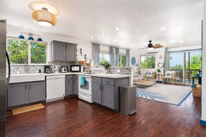 A modern kitchen with grey cabinets, a white countertop, and a built-in oven.