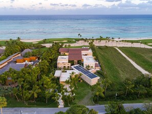 An aerial view of a resort with buildings, a beach, and palm trees. - Villa Tartaruga - Ocean-front villa with unique amenities and full service staff (Punta Cana)