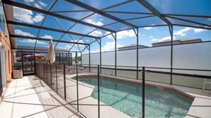 En pool på taket, omgiven av glas, med kristallklart vatten och utsikt över himlen och byggnaderna.