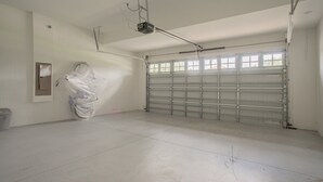 Eine Garage mit einer geschlossenen Metalldecke, einem auf dem Boden verpackten Gegenstand und einer Deckenleuchte.