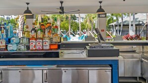 Zona de bar con varias botellas de licor y un cartel de Tequila Patrón.