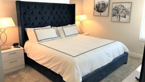 A bedroom with a large bed, two bedside tables, and wall art. - Spacious 5-bedroom townhouse in Kissimmee, perfect for family getaways! (Kissimmee)