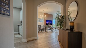 Un intérieur moderne comprenant un coin repas, un téléviseur et un miroir décoratif.