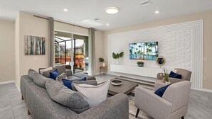 A modern living room with a grey sofa, a coffee table, and a TV wall.