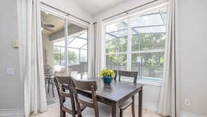 A dining area with a table, chairs, and a potted plant. - Spacious 4-bedroom home in Kissimmee, perfect for family getaways! (Kissimmee)