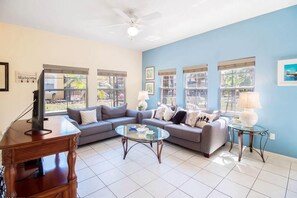 Relax in this stylish living room with a large sofa, coffee table, and TV on a wooden stand.