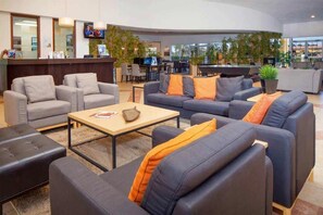 Relax in our spacious lobby, featuring a reception desk, comfortable seating areas, and a bar.