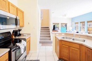Kitchen features a large island with a sink and a window offering a view of the outside.
