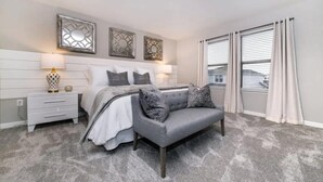 A bedroom with a bed, nightstands, a chair, and a window with curtains. - Spacious 5-bedroom home in Kissimmee, perfect for family getaways! (Kissimmee)
