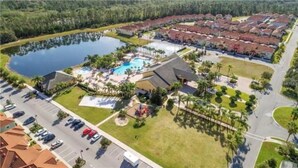 An aerial view of a resort with a swimming pool, multiple buildings, and a parking lot. - Spacious 4BR Kissimmee Townhome with Private Pool, sleeps 12 in Paradise Palms. (Kissimmee)