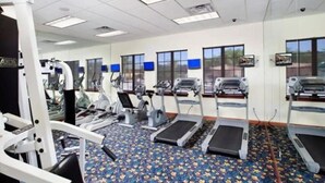 A gym with treadmills, elliptical machines, and weightlifting equipment. - Spacious 4BR Kissimmee Townhome with Private Pool, sleeps 12 in Paradise Palms. (Kissimmee)