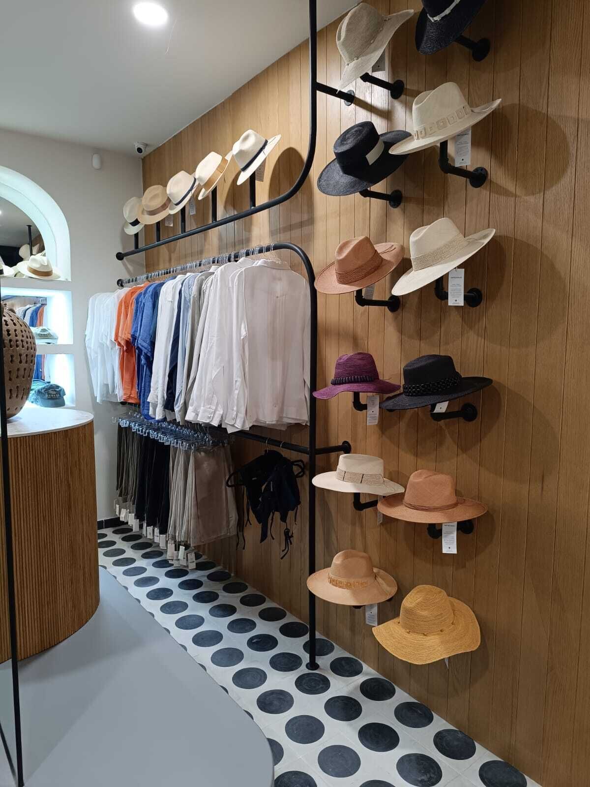 A clothing and hat store with racks of clothes and hats.