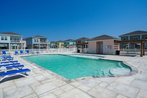 Relax by the pool surrounded by a clear water feature and lounge chairs in a well-maintained outdoor space.
