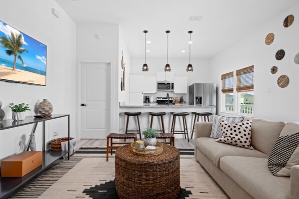 Relax in this stylish living space with a comfortable sofa, flat-screen TV, and kitchen area.