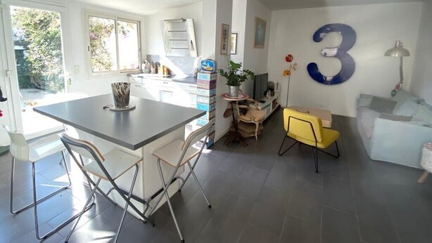 A modern kitchen with a central island, a dining area with chairs, and a large number '3' on the wall. - Charming villa 2 bedrooms swimming pool Wi-Fi air conditioning parking (CANET PLAGE)