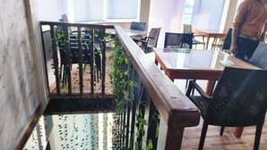 Un espace intérieur moderne avec un escalier en bois, des chaises noires et une table.