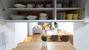 Eine moderne Küche mit weißen Schränken, einer Holzausziehtischplatte und einem Essbereich mit Tisch und Stühlen.