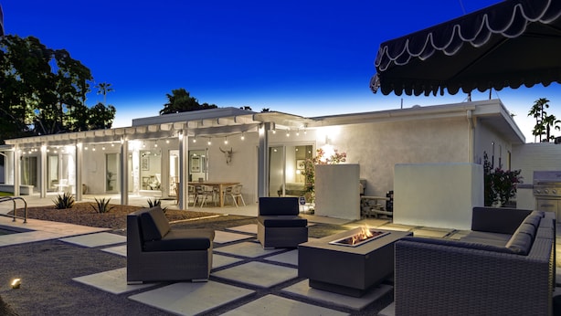 An outdoor patio area with modern furniture, a fire pit, and a covered seating area. - Spectacular Luce  Desert Escape-  Oversized Resort setting + golf cart (Palm Desert)