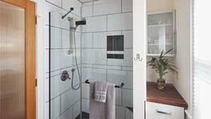 A modern bathroom with a glass-enclosed shower, a wooden vanity, and a potted plant. - The Madrona House!
Freshly renovated bungalow / detached studio/office space. (Portland)