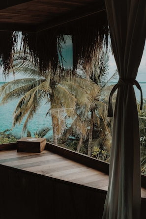 Una habitación con vista al mar y palmeras.