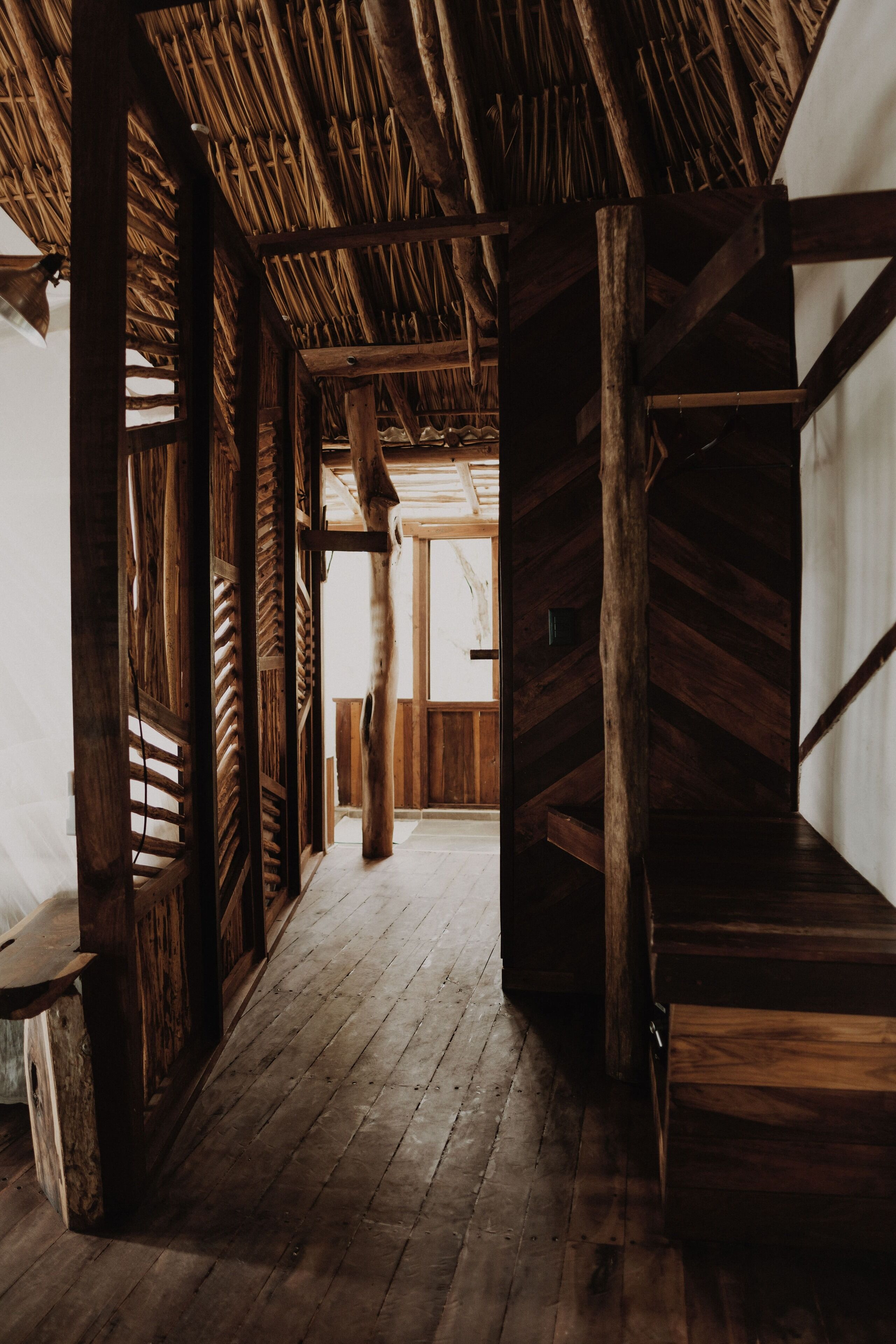 A wooden interior with a sloped ceiling and a central wooden column.