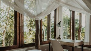 A bedroom with a bed, a desk, and a chair. There are large windows with curtains. - BoaBoa Bacalar (Bacalar)