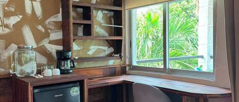 A corner room with a desk, chair, and built-in shelves.