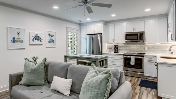 A modern kitchen with white cabinets, a stainless steel refrigerator, and a microwave.