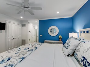 A bedroom with a bed, a nightstand, a mirror, and a ceiling fan. - Near Crawford Historic Square, Heated Pool Access (Savannah)