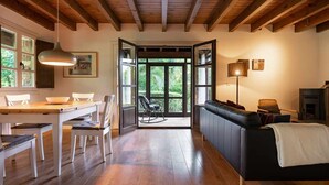 A spacious room with a wooden ceiling, a dining area with a table and chairs, a sofa, and a fireplace. - CASA ESCONDIDA CUENCU (Cuenco)