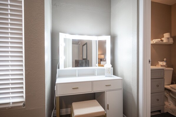 Een badkamer met een wastafel, een spiegel en een toilet.