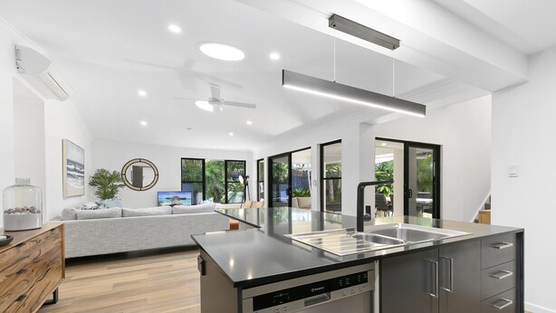 A modern kitchen with a dishwasher, a built-in oven, and a large island with a sink. - Central Tropical Oasis with Pool - Pet Friendly (Noosaville)