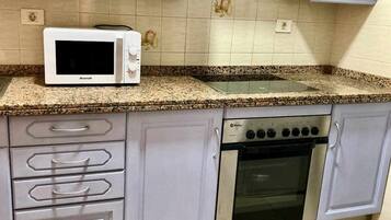 Een magnetron, een oven, een broodrooster, kookgerei, borden en bestek