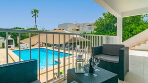 Ein Balkon mit Pool, Gartenmöbeln und einer Treppe.