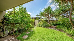 A well-maintained garden with a stone pathway leading to a building. - 5 mins walk to Hastings Street (Noosa)
