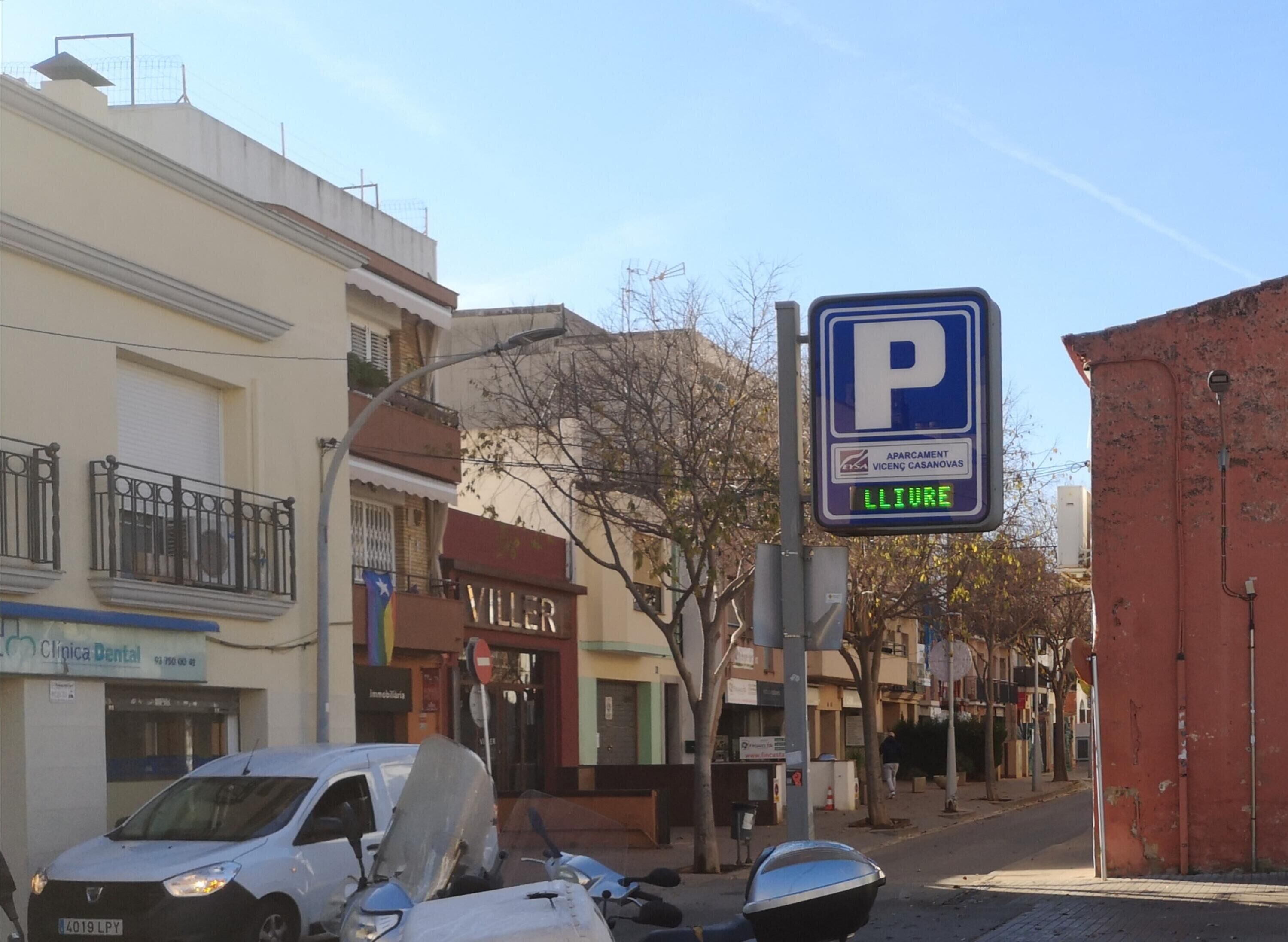 Escena callejera con una señal de estacionamiento, una clínica dental y un edificio con un letrero que dice 'VILLER'.