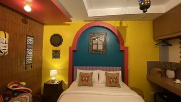 Una stanza arredata con un letto, un comodino, una lampada, una parete decorata e un lampadario.