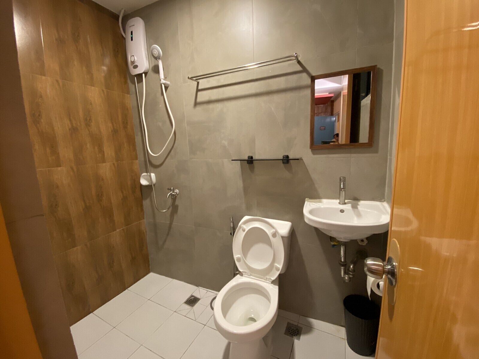 Une salle de bain avec douche, toilettes et lavabo.