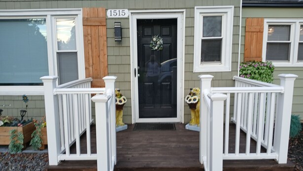 A house with a front porch, a black door, and a mailbox.
