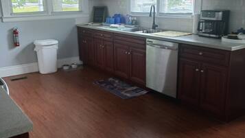 A kitchen with wooden cabinets, a stainless steel dishwasher, and a coffee maker.